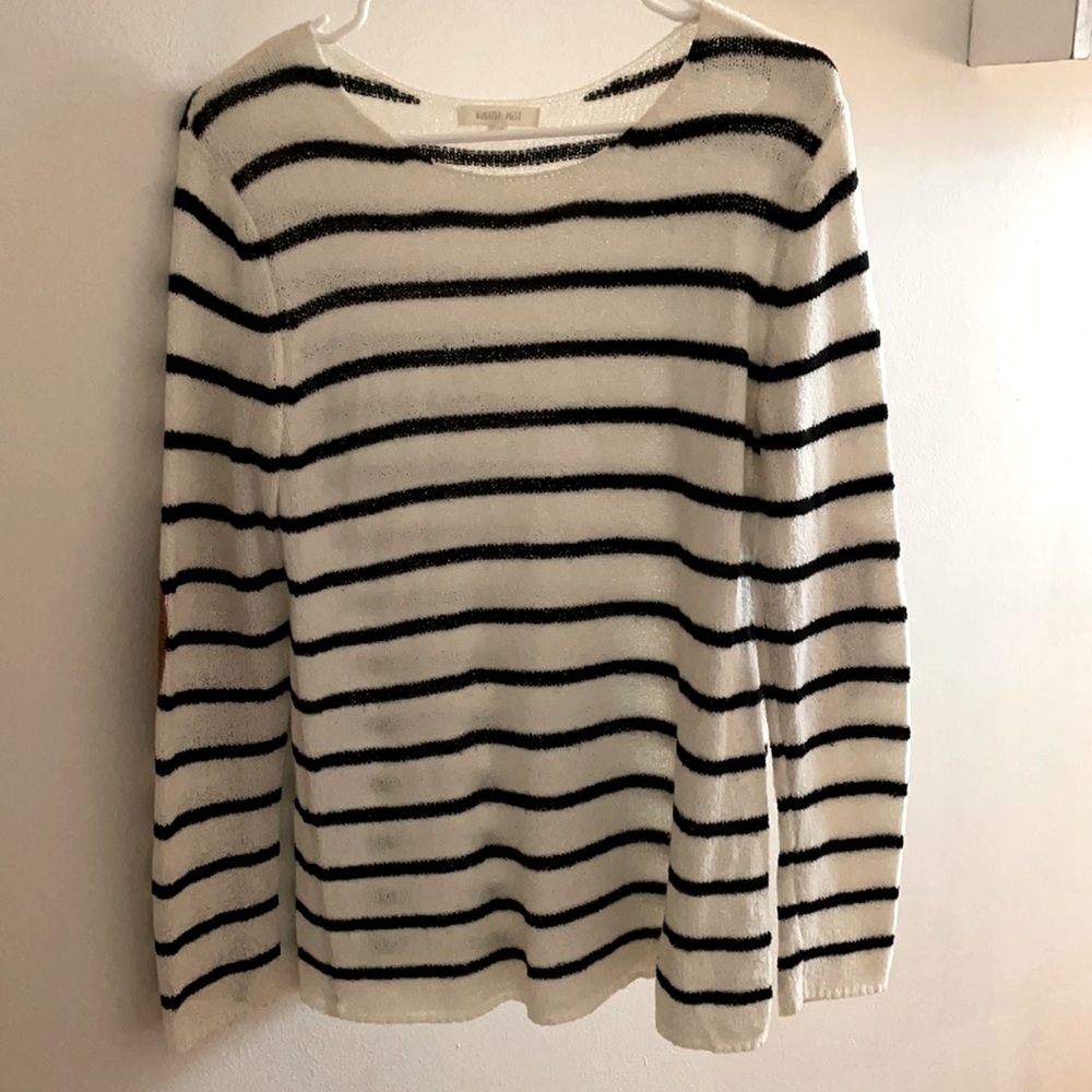 White and black sweater with elbow detailing.